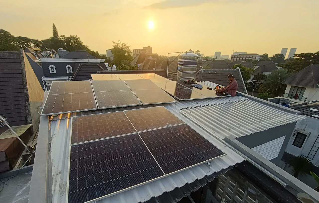 Panel surya terpasang di atap metal rumah di Depok saat matahari sore