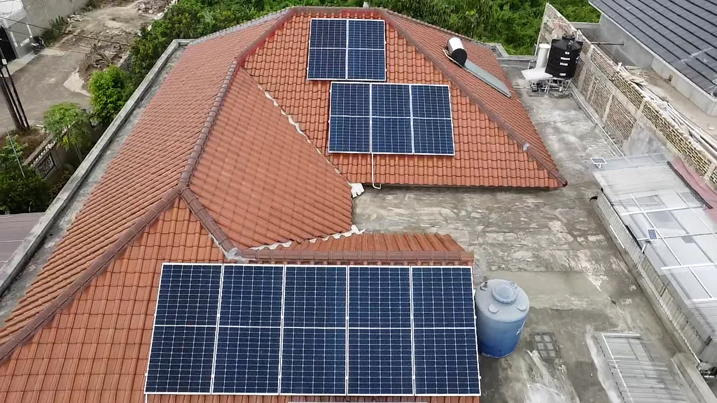 Tiga kelompok panel surya terpasang pada bidang atap genteng rumah di Duren Sawit