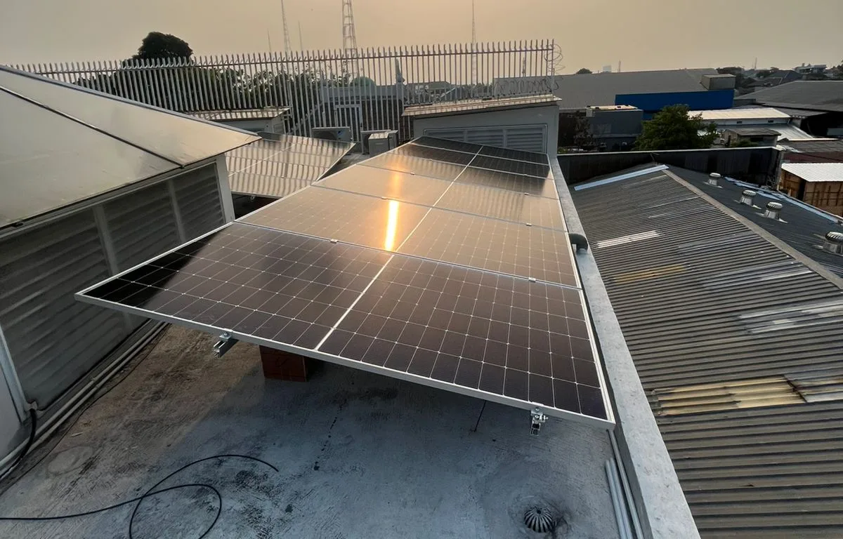 Deretan panel surya pada rangka miring di atap dak beton di Jakarta Barat