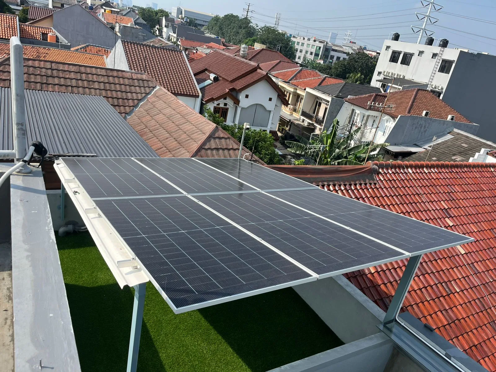 Panel surya pada rangka miring di atas teras atap rumah di Jakarta Timur